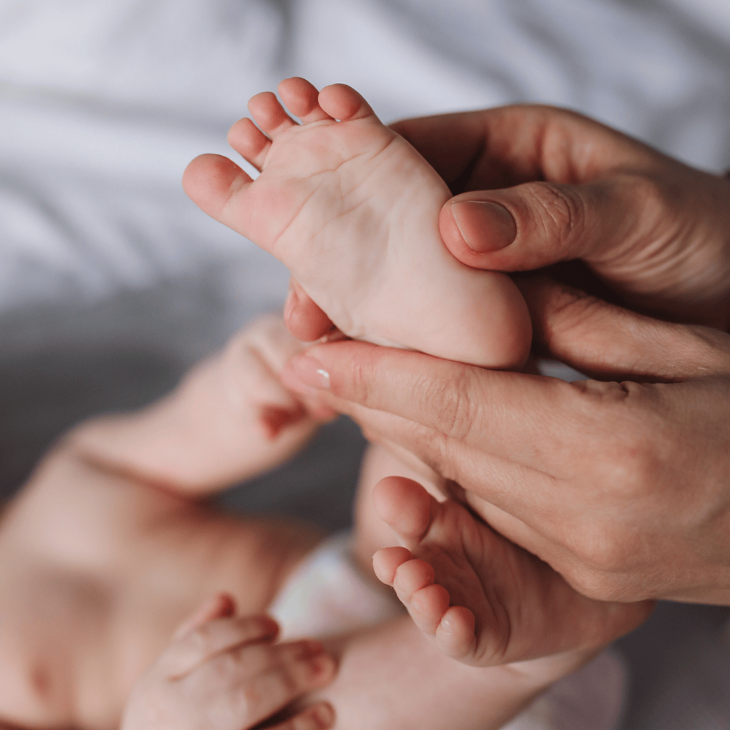 A baby's foot being massaged by a parent in an infant massage class